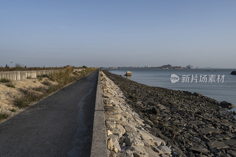 沿海的道路和远处的化工厂