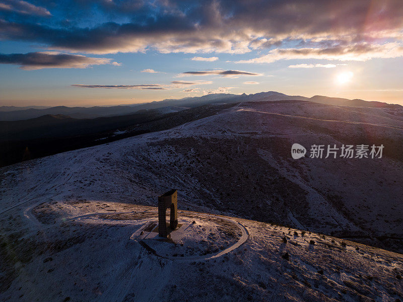 冬季清晨，保加利亚巴尔干山脉主山脊上白雪覆盖的山脉和自由纪念碑拱门的美丽鸟瞰图