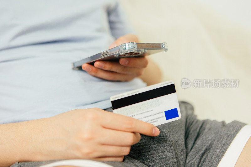 一个拿着信用卡的男人看着账单，感到很难过——生活方式和科技，支付方式和账单