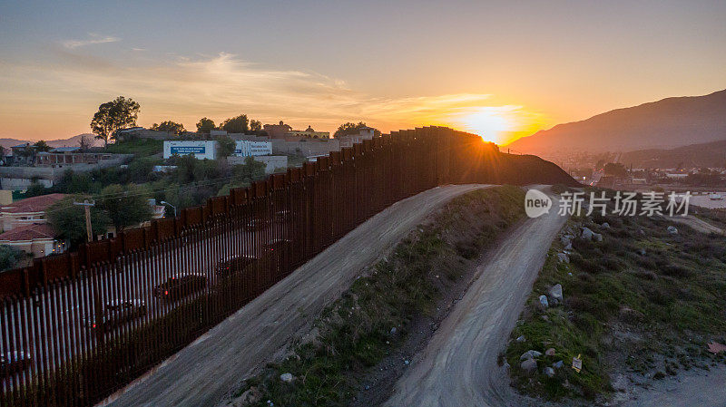 在黄昏时分，在令人惊叹的日落下，从美国俯瞰这座城市，在蒂华纳附近的加利福尼亚和墨西哥的特卡特之间的国际边界墙