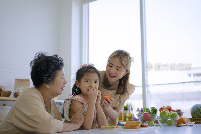 奶奶、妈妈和孙女在厨房准备食物。