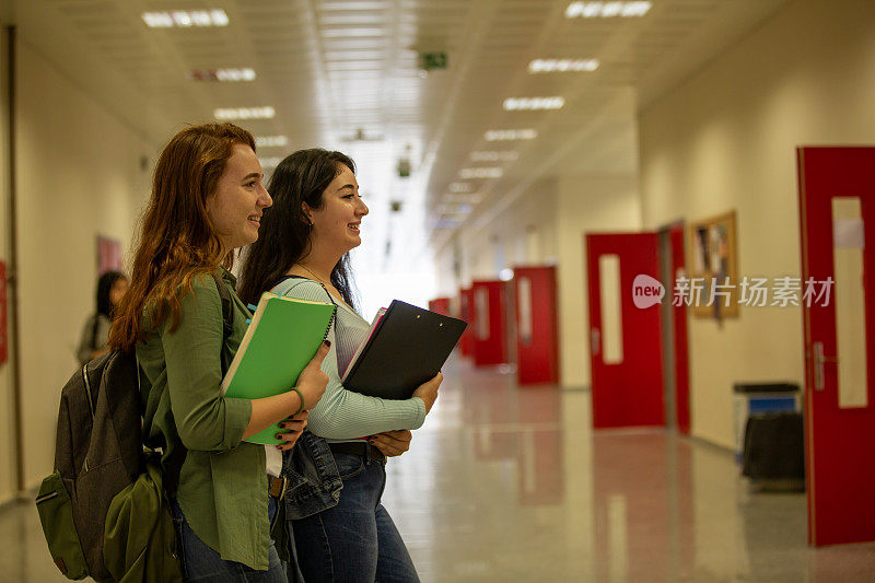 课间休息时，快乐的年轻大学生站在走廊上