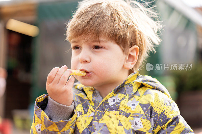 小男孩吃零食的照片