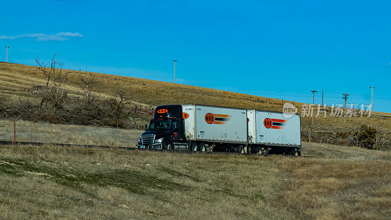 一辆中西部汽车快车(MME)，一家LTL货运公司，在90号州际公路上向西行驶，驶向美国华盛顿州西雅图。