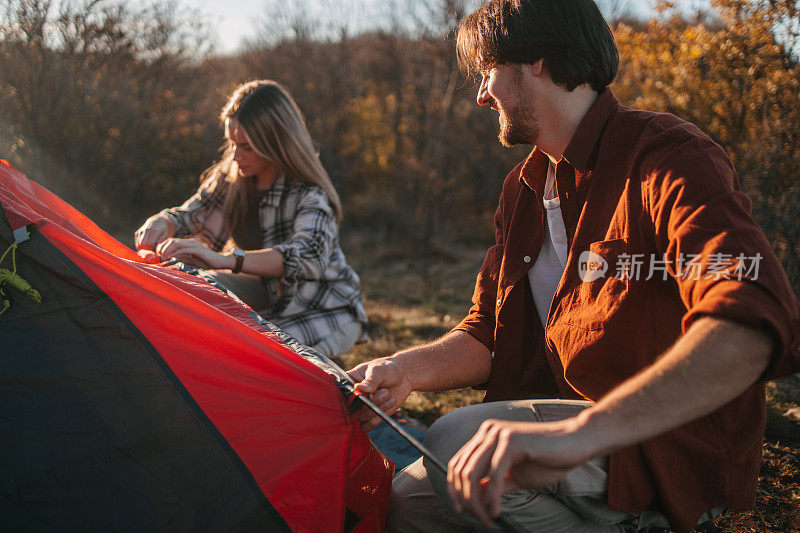 一对夫妇一起搭起了露营帐篷