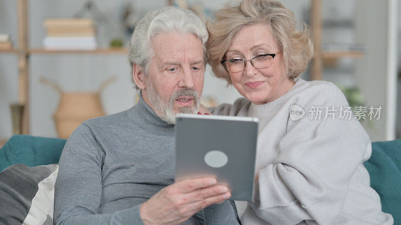 在家里一起使用平板电脑的相爱的老夫妇