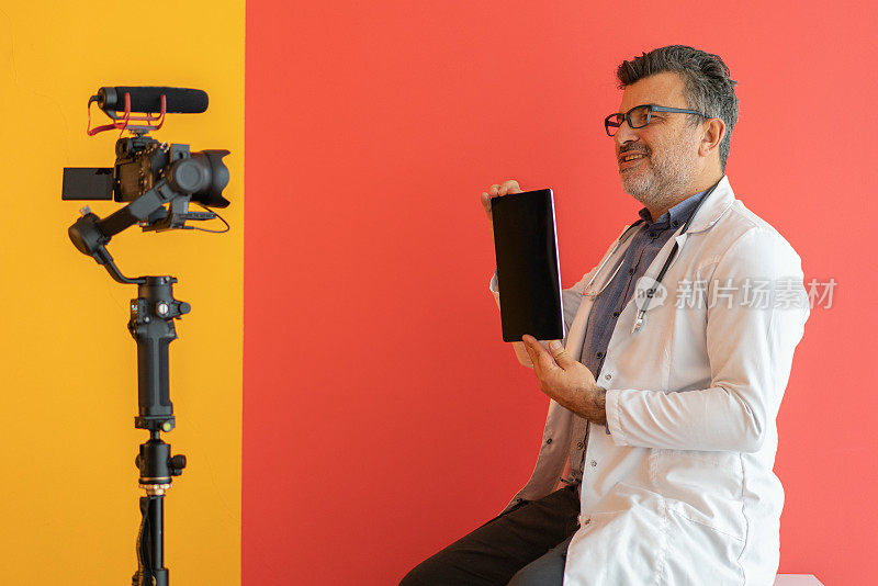儿科医生与数字平板电脑，而视频视频对彩色背景