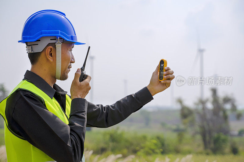 在发电厂工作的蓝领工人。风车。