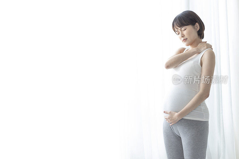 孕妇站着手放肩膀