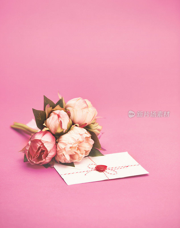 母亲节的背景与一束牡丹花和一个字母在一个粉红色的背景与文字空间