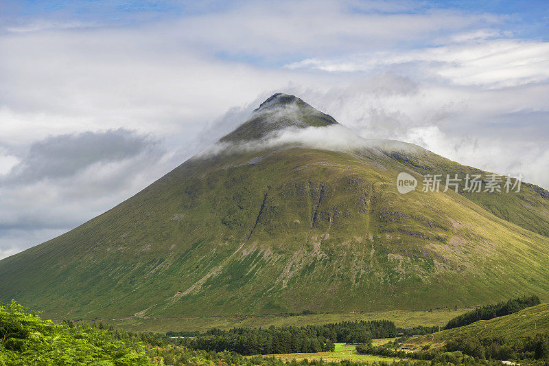 在英国苏格兰的高地上，穿过山谷看到金字塔形状的山