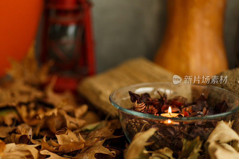 特写镜头的玻璃碗充满了百花香和茶蜡烛燃烧在中间