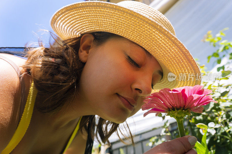 一个试着闻粉色雏菊的女人