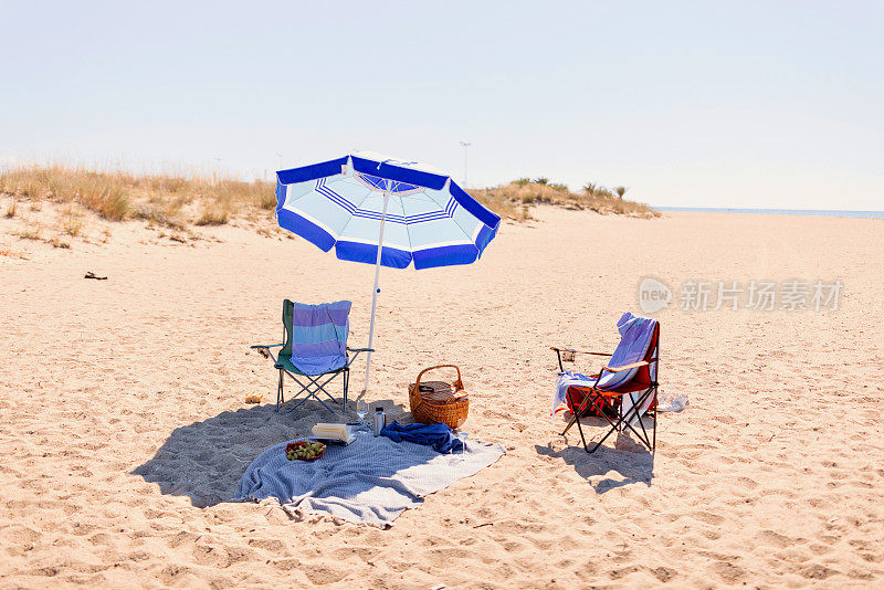 配有椅子和沙滩配件的沙滩伞
