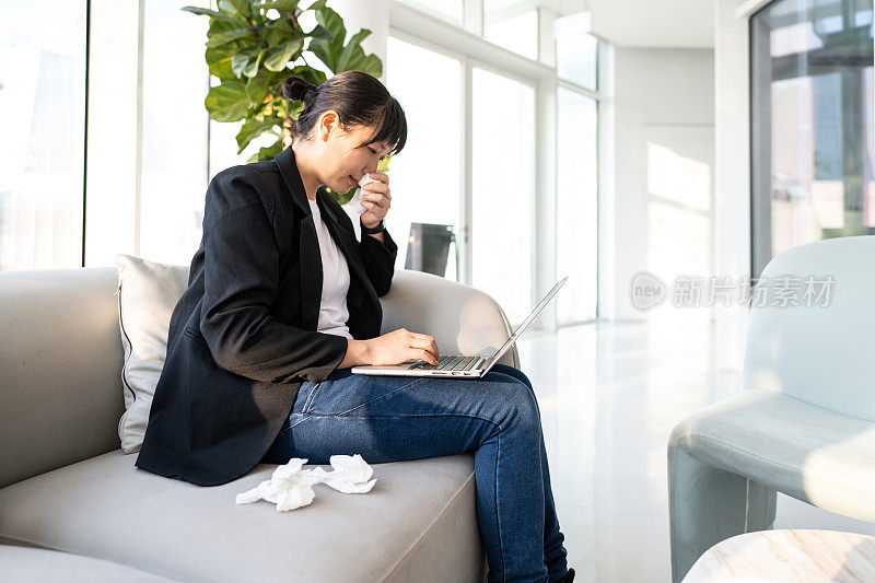 一位女白领生病了，在家里用笔记本电脑工作