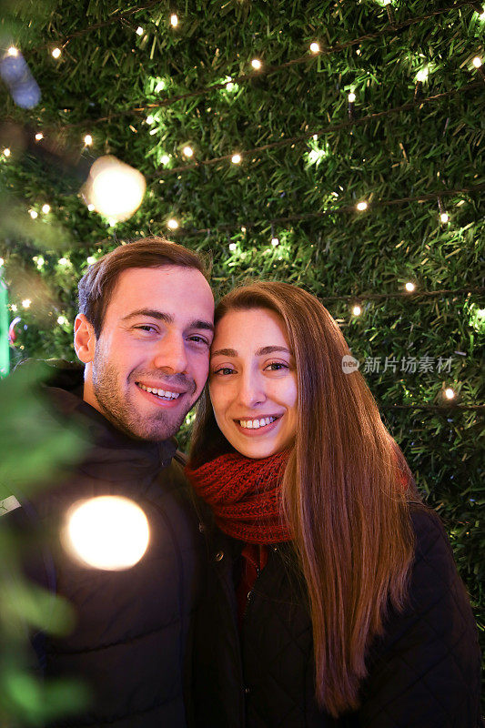 幸福的情侣在圣诞彩灯前