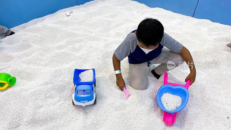 男孩在室内玩沙子