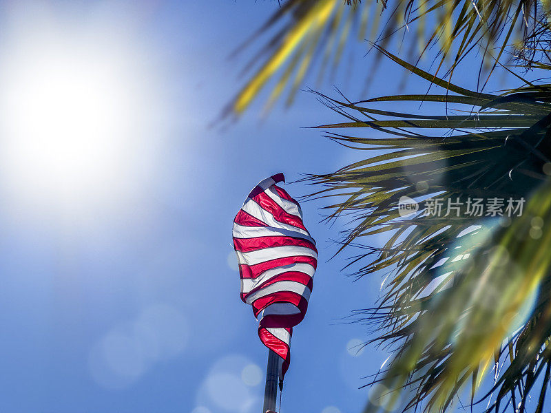 美国国旗在阳光明媚的蓝天上飘扬