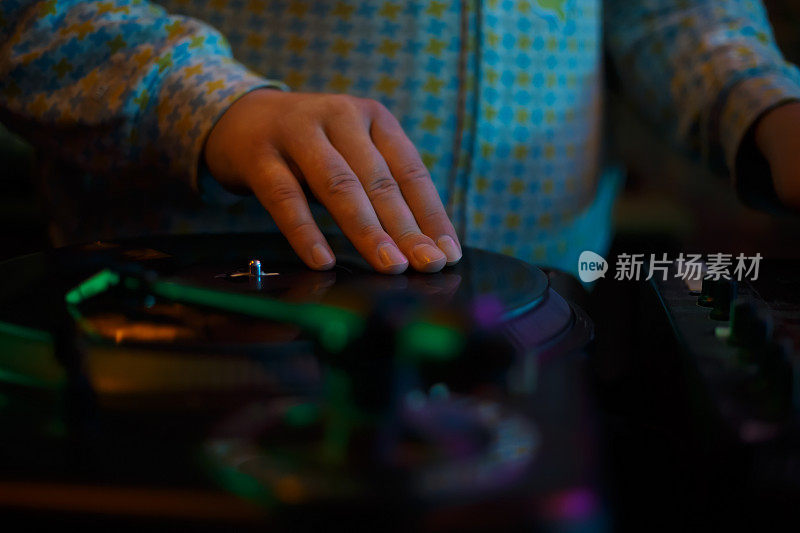 嘻哈DJ在转盘上刮黑胶唱片。俱乐部唱片师在派对上擦唱片