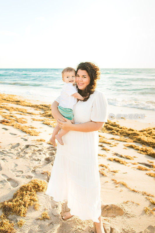 2023年春天，佛罗里达州棕榈滩，一位31岁的古巴母亲抱着她1岁的儿子在沙滩上享受金色日出的时光