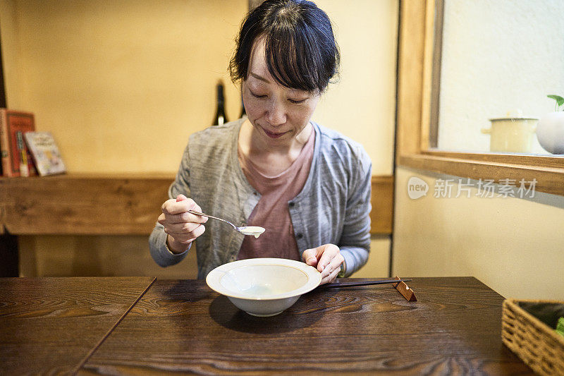 一位亚洲妇女在素食餐厅吃素食午餐。