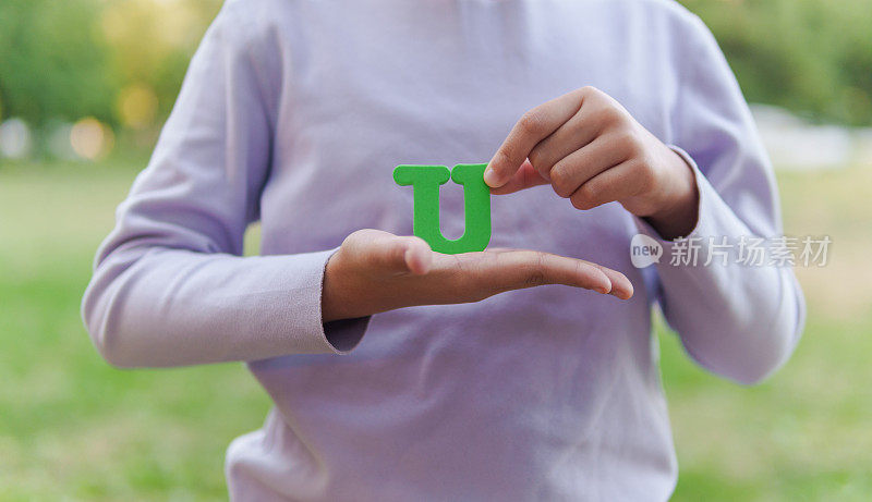 小孩拿着字母“U”