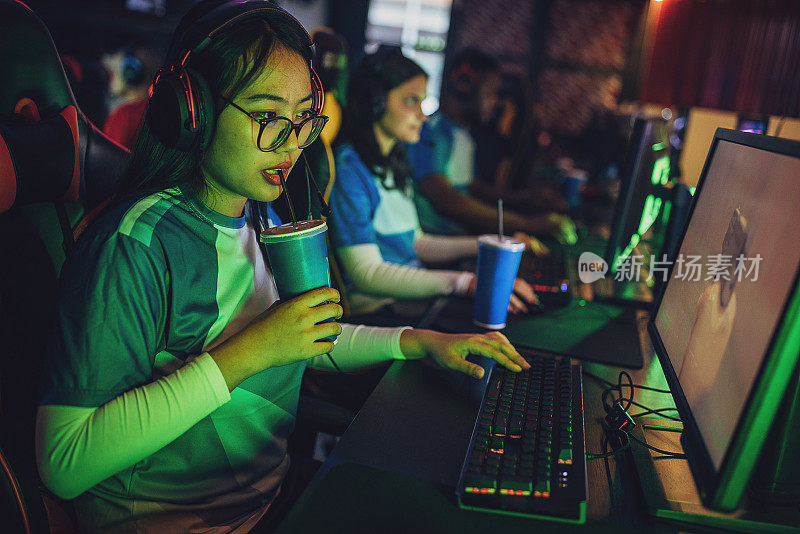 职业电子竞技年轻亚洲女玩家喝提神饮料