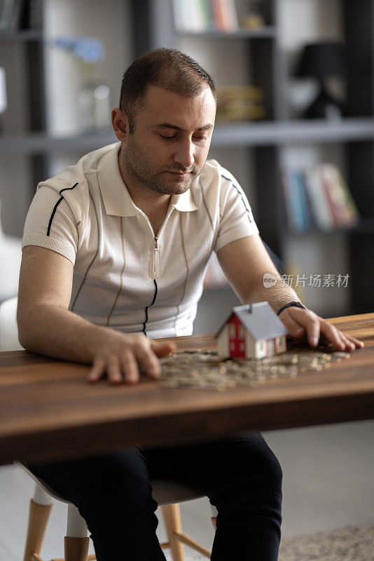 房屋模型和硬币持有人在桌子上的钱为金融和银行的概念。