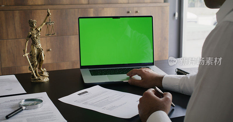 商人在办公室使用带有色度键绿屏的笔记本电脑