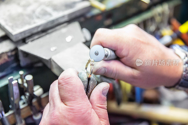 一个珠宝商在他的工作台上修理一枚钻石戒指