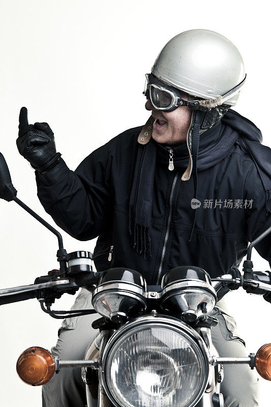 男人戴着头盔和眼镜驾驶摩托车