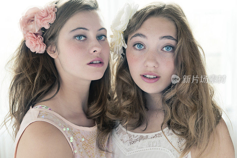 两个漂亮的姑娘，新鲜的脸蛋，头上插着花。