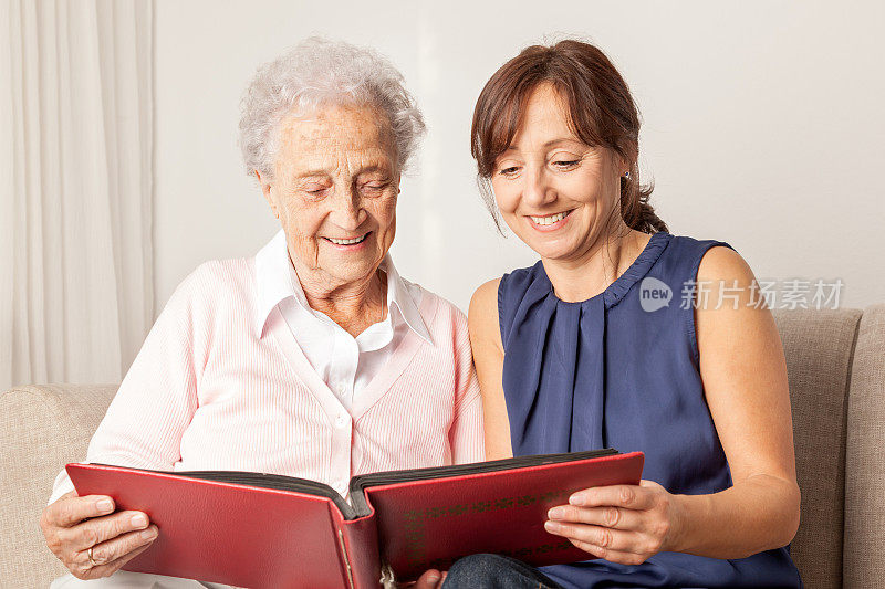 年长女性和家庭看护在看相册