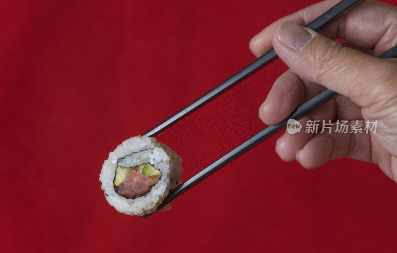 手握筷子和寿司