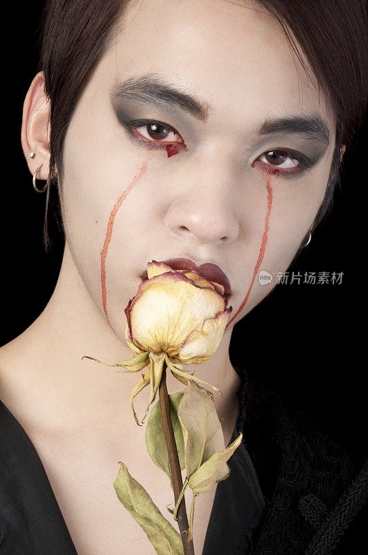 哭泣的亚洲男性吸血鬼和干玫瑰。