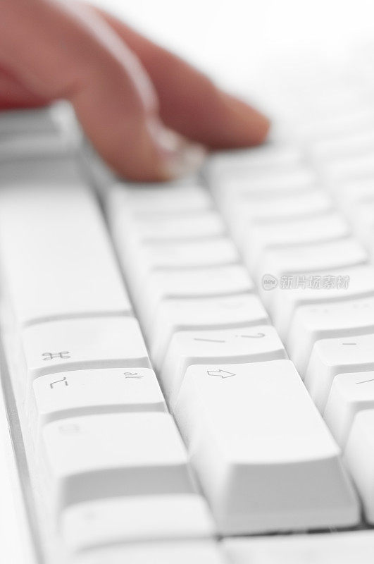 手指在白色的电脑键盘上敲击