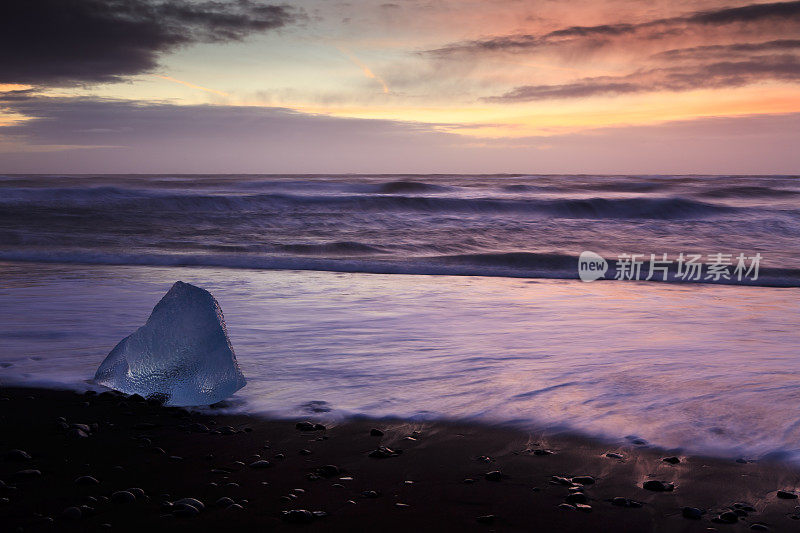 日出时冰岛Jokulsarlon海滩上的冰山