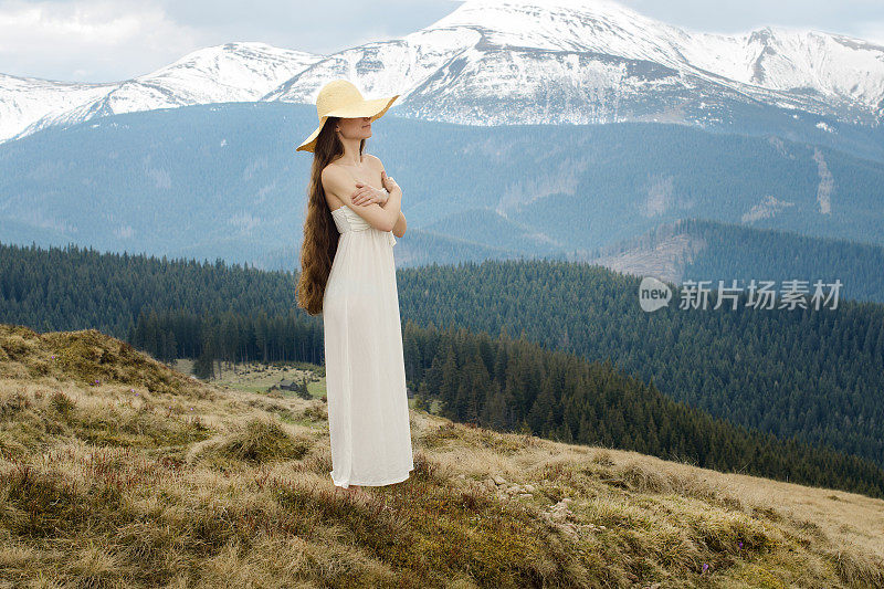 年轻女子站在山的山坡上