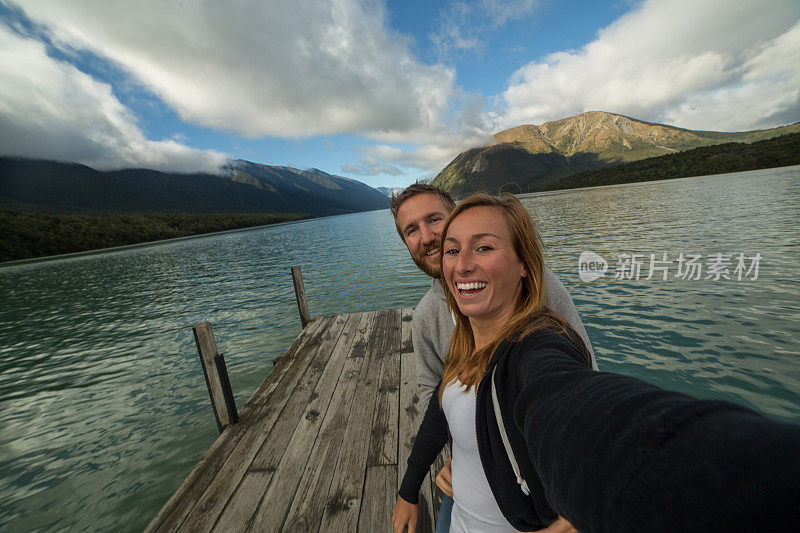 年轻夫妇站在湖边码头的自画像