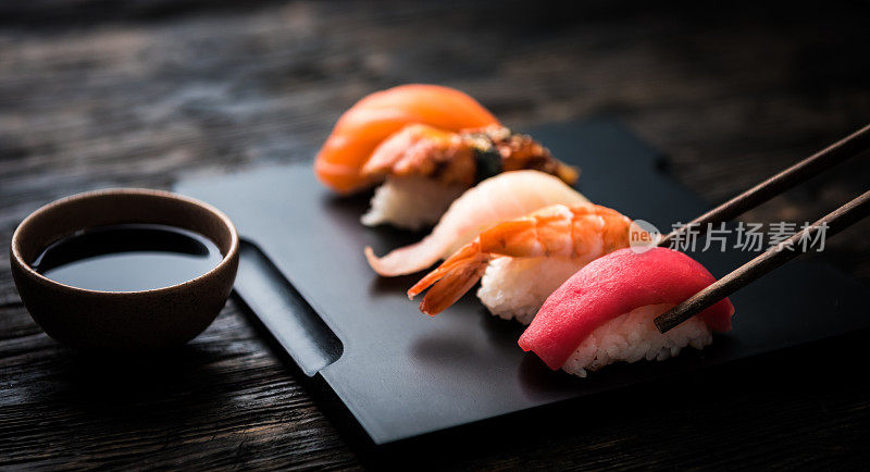 近距离的生鱼片寿司与筷子和酱油