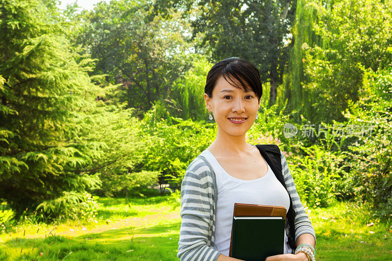 在校园内持书的亚洲女学生