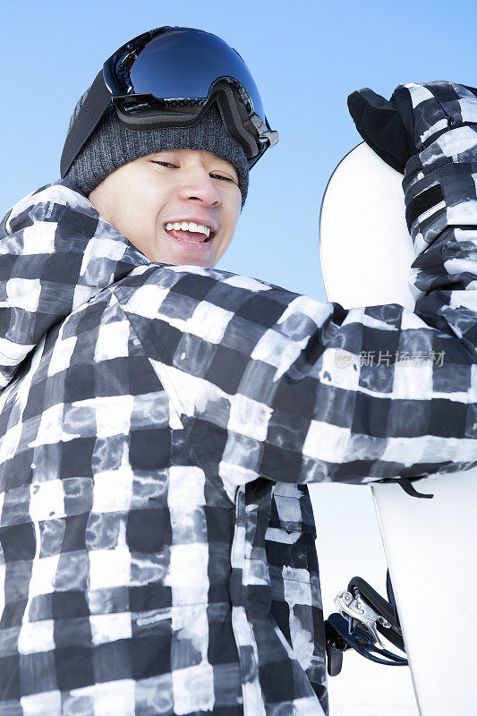 快乐的男性滑雪板对蓝色的天空