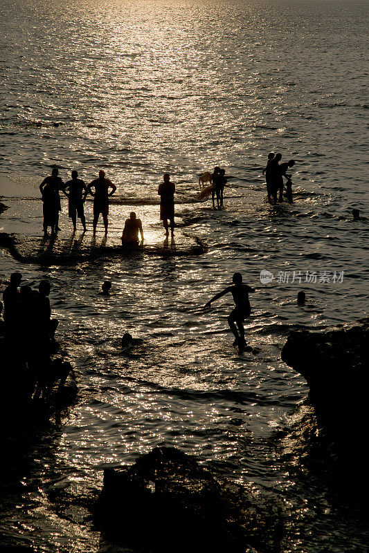 人们在黎巴嫩贝鲁特的岩石海岸游泳