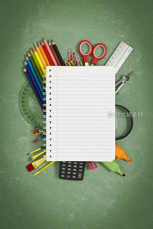 空白笔记本上的彩色学校用品