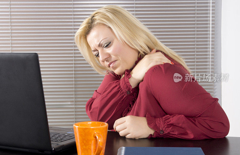脖子疼的女商人坐在电脑前
