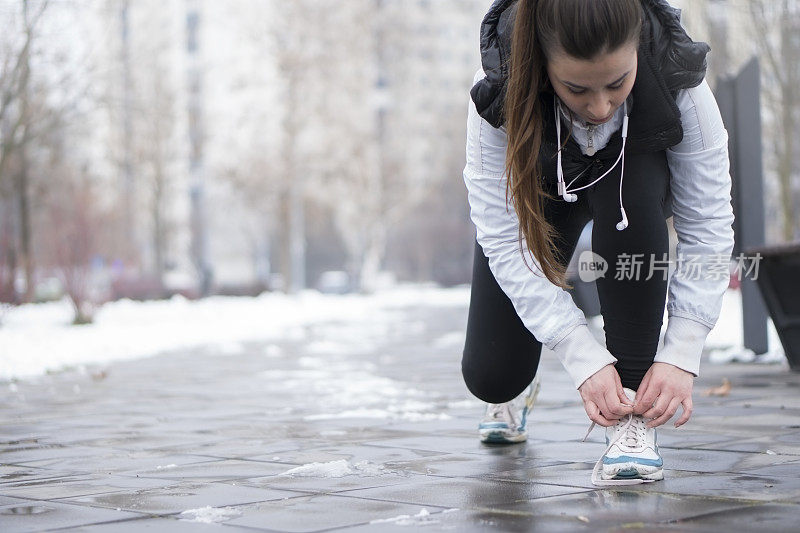 年轻女性跑步者系鞋带