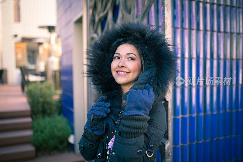 年轻女子在寒冷的冬天穿着暖和的夹克