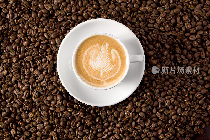 卡布奇诺与复杂的泡沫设计围绕咖啡豆