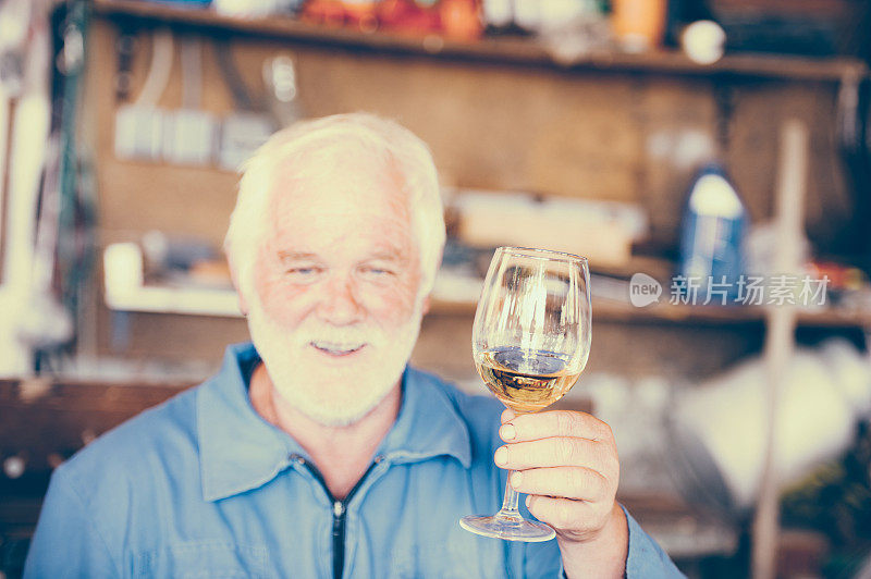 胡子老人喝着白葡萄酒