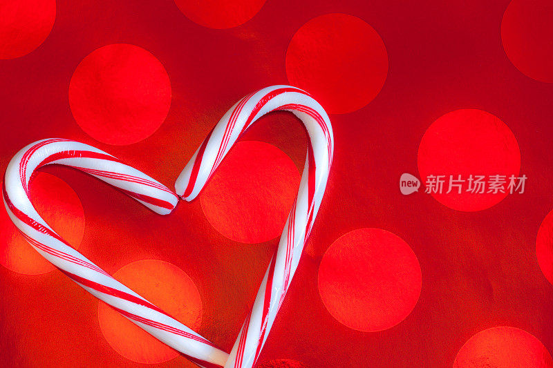 红色背景上两根心形的圣诞拐杖糖果(P)